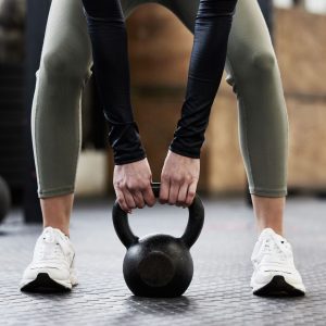 Mujer entrenando potencia con pesa rusa en postura correcta durante la perimenopausia